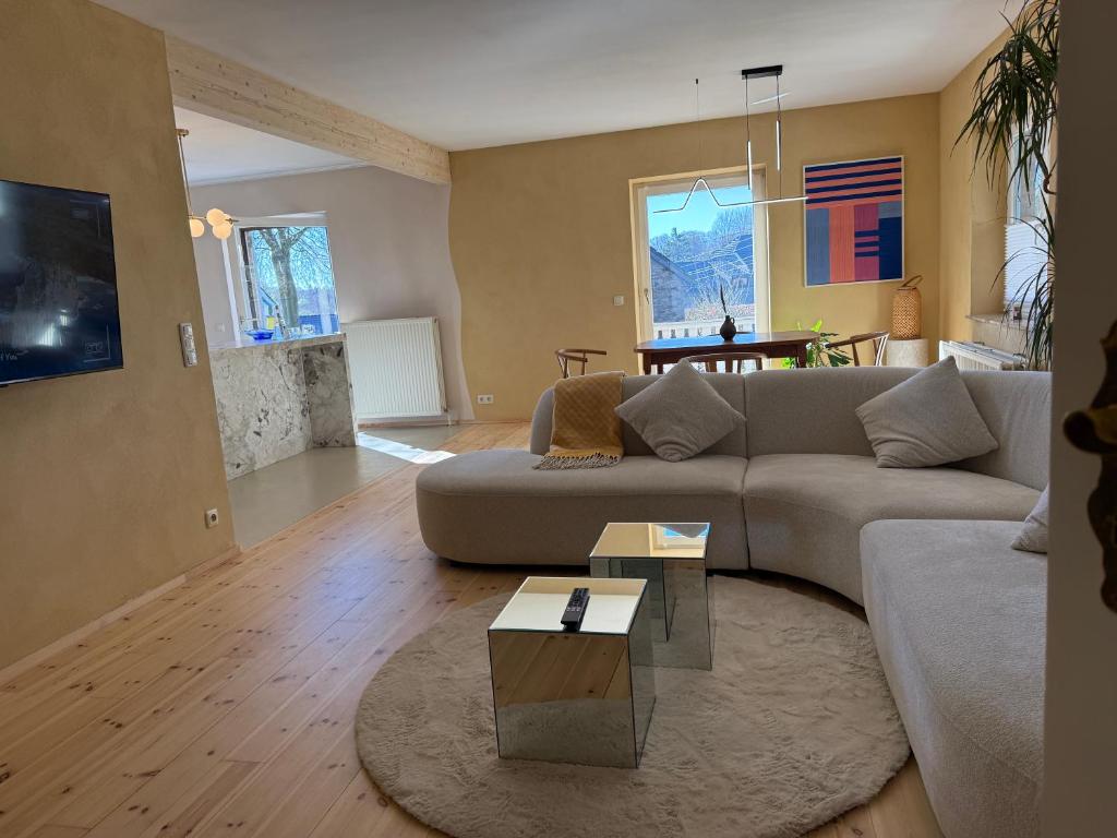 a living room with a couch and a table at Rainbow Bungalow in Butgenbach