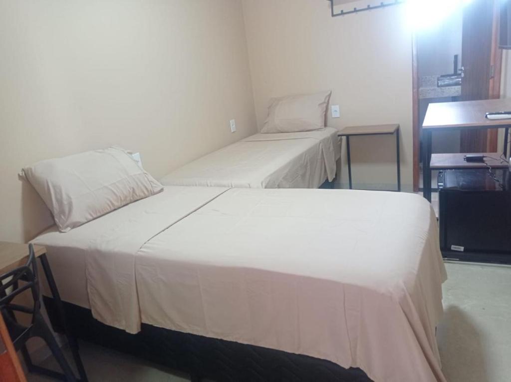 a room with two beds in a room at Hotel Lorenna in Santa Inês