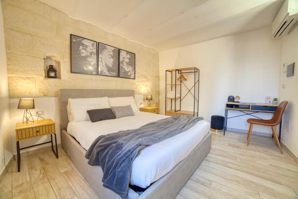 a bedroom with a large white bed and a desk at SASSARI-CENTRO Elegante Appartamento con WiFi e Netflix in Sassari