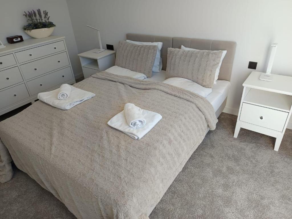 a bedroom with a bed with two towels on it at PINEA 2 BEDROOM APARTMENT WITH Sea VIEW in Pobierowo