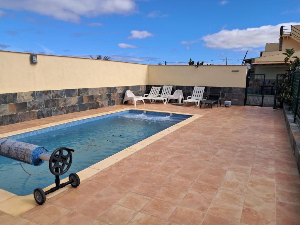 a swimming pool with a toy in front of a house at El cortijo de Valverde in Lajares