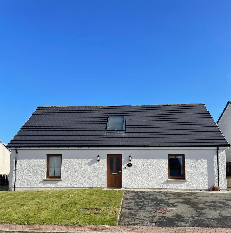 a white house with a black roof at 3 Breckan Brae in Orkney