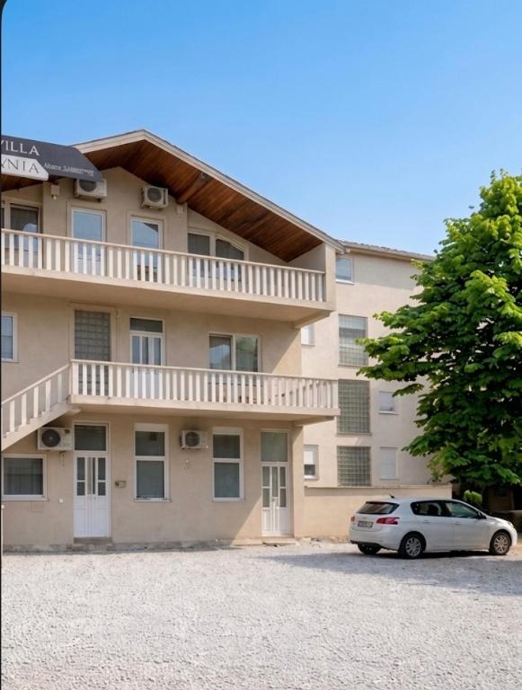 a white car parked in front of a building at Villa Anja Apartments in Mostar