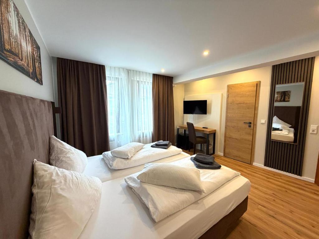 a hotel room with two beds with white pillows at Bacharacher Hof in Bacharach