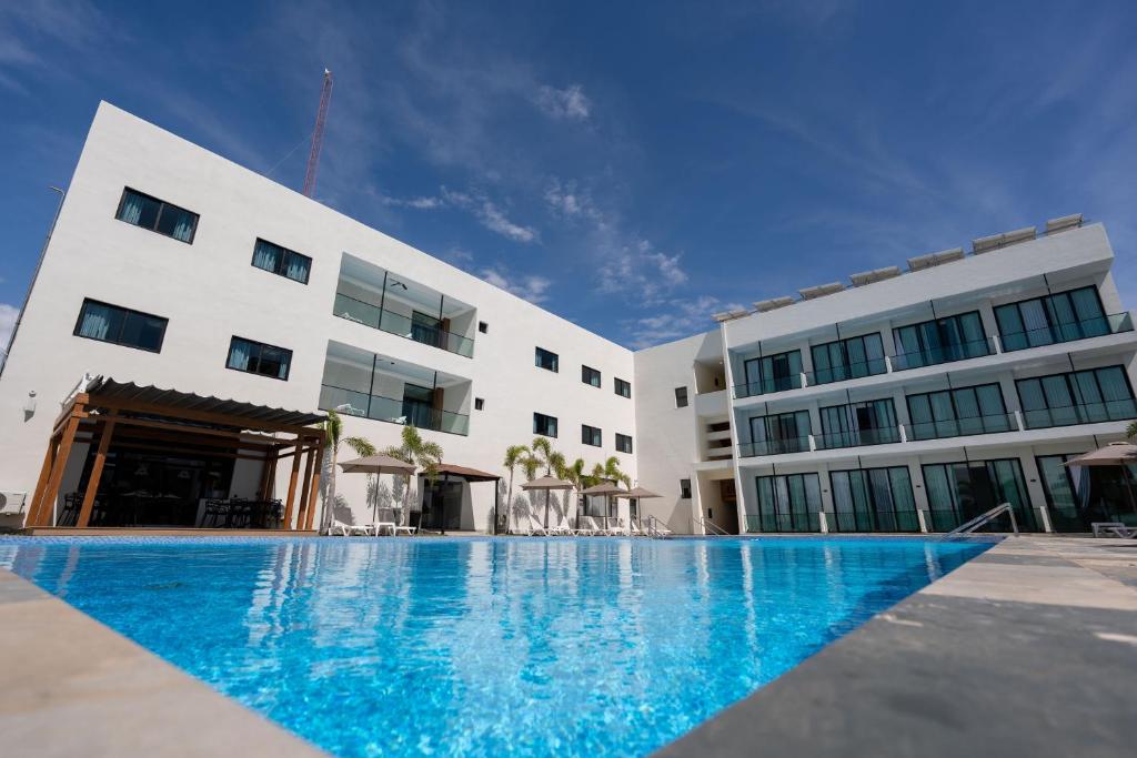 a swimming pool in front of a building at Hotel Anselmo in Boca Chica