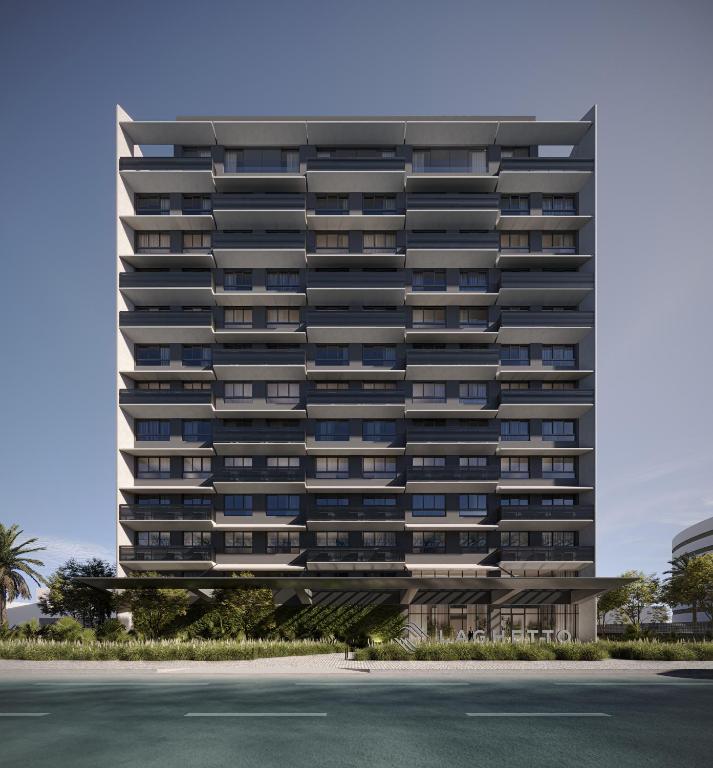 a tall building with a parking lot in front of it at Laghetto Stilo Aeroporto in Porto Alegre
