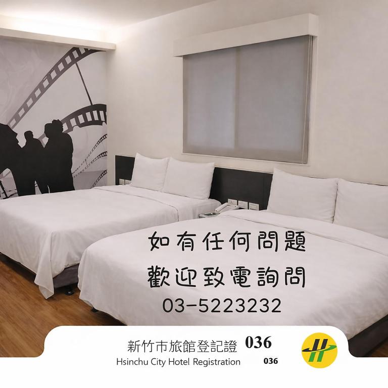 two beds in a room with writing on the wall at Persimmon Hotel in Hsinchu City