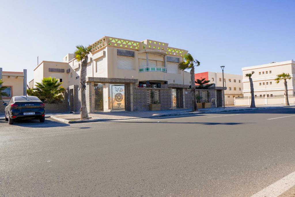 a building with a car parked on the side of a street at villa karima dakhla prestige in Dakhla