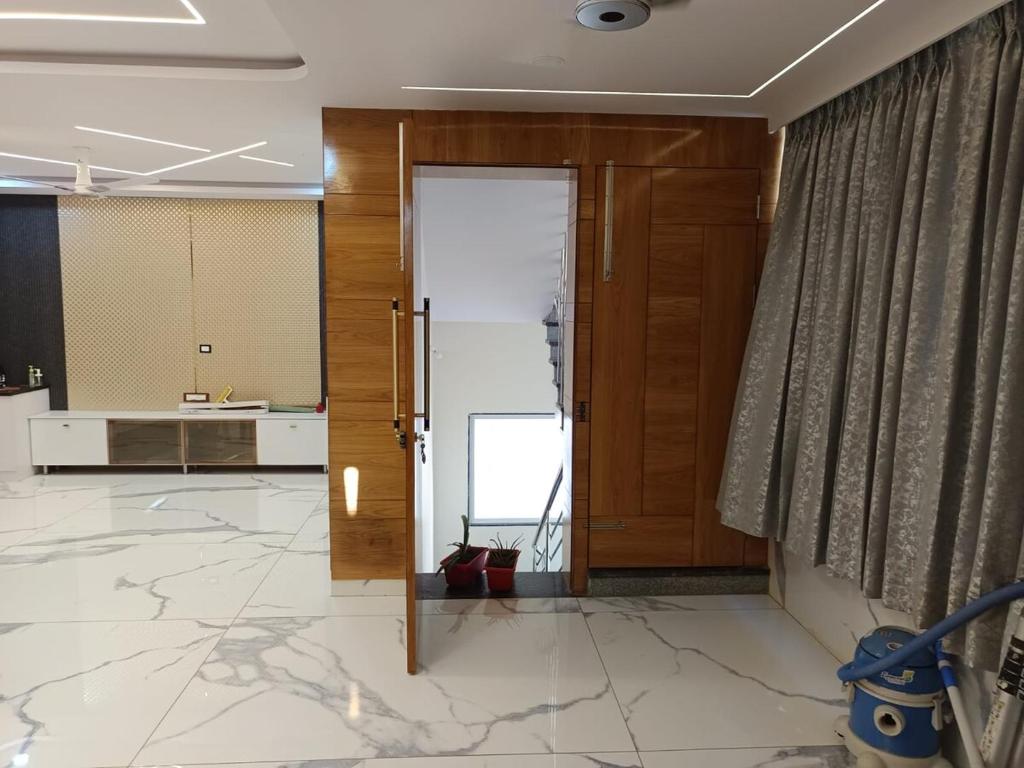 an open door in a lobby with a person standing behind it at Ganesh Nilayam in Hyderabad