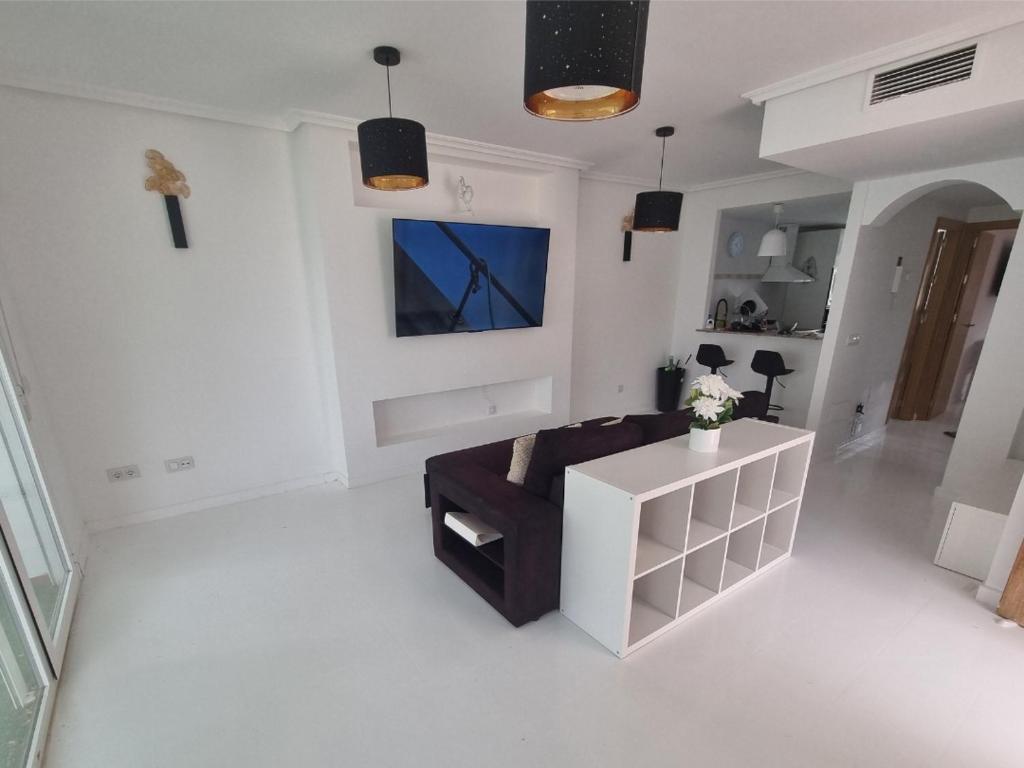 a living room with a couch and a tv at Hidden Gem between Waves & Mountains in Lo Gea