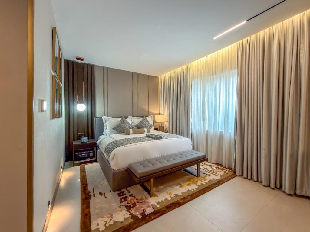 a bedroom with a bed and a large window at The Lusso Hotel in Abuja