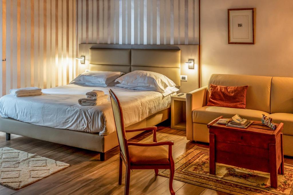 a bedroom with a bed and a couch and a chair at Casa Lanzara - Dimora Storica nel cuore del Pollino in Morano Calabro