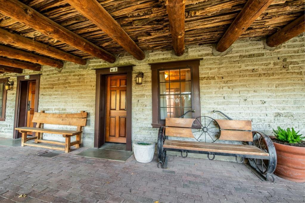 a porch with two benches on a brick house at Tanque Verde Guest Ranch in Tucson