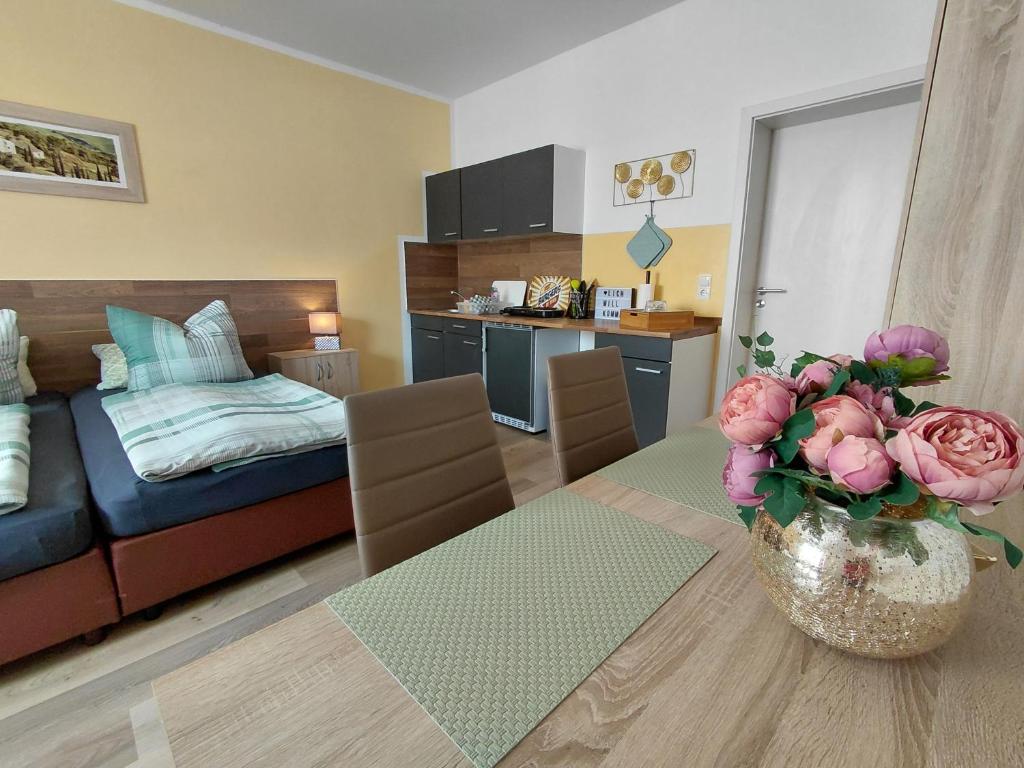 ein Wohnzimmer mit einer Couch und einem Tisch mit Blumen in der Unterkunft Doppelappartement CityImmo in Gotha