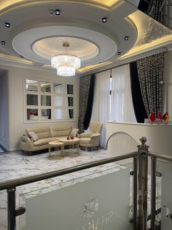 a living room with a couch and a chandelier at Shahzam Hotel in Samarkand