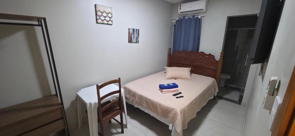 a small room with a small bed and a table at Hangar House in Belém