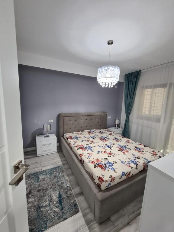 a bedroom with a bed and a chandelier at Romanescu Park Apartament in Craiova
