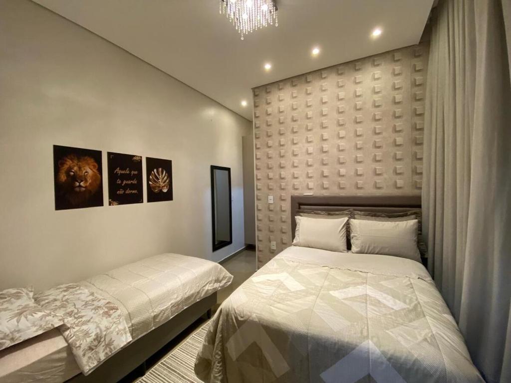 a bedroom with a bed and a headboard at Casa linda e nova, 01 suíte, 02 camas - até 03 pessoas in Chapecó