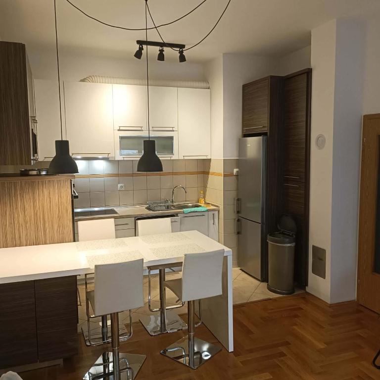 a kitchen with a table and chairs and a refrigerator at River & Garden Apartment in Trebinje