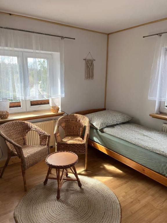 a bedroom with a bed and two chairs and a table at Nad Stawami - studio in Białowieża