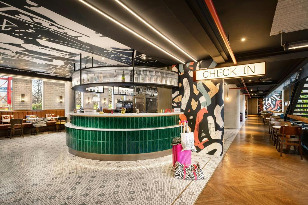 a restaurant with a check in counter and a bar at Moxy Paris La Villette in Paris