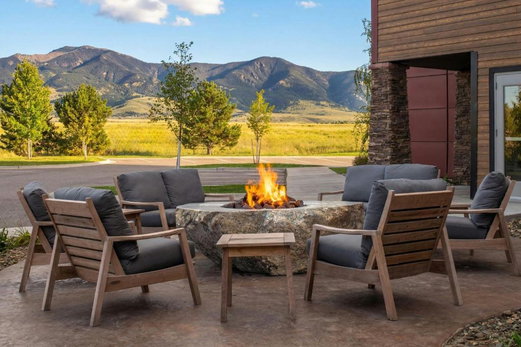 a patio with a fire pit and chairs and mountains at Residence Inn Bozeman in Bozeman