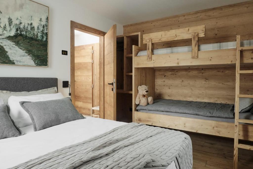 a bedroom with a bunk bed and a teddy bear at Alp Tirol Home in Pellizzano