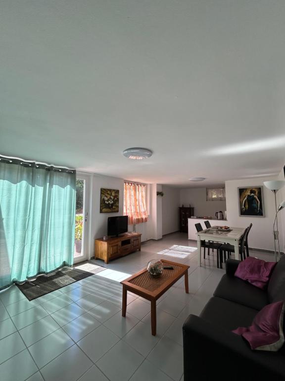 ein Wohnzimmer mit Sofa und Tisch in der Unterkunft Parco Delle Valli in Sassari