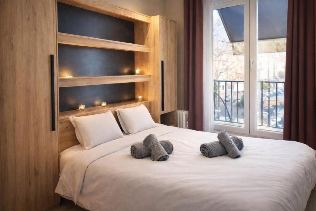 a bedroom with a large white bed with two pillows at Le 5 Place Carnot in Douai