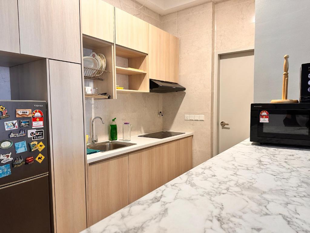 a kitchen with a sink and a refrigerator at ANTARA Muji Serenity Condo in Putrajaya