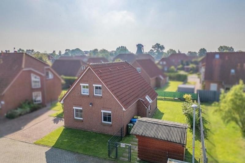 a house with a roof on top of a yard at SörenHuus Neßmersiel in Dornum