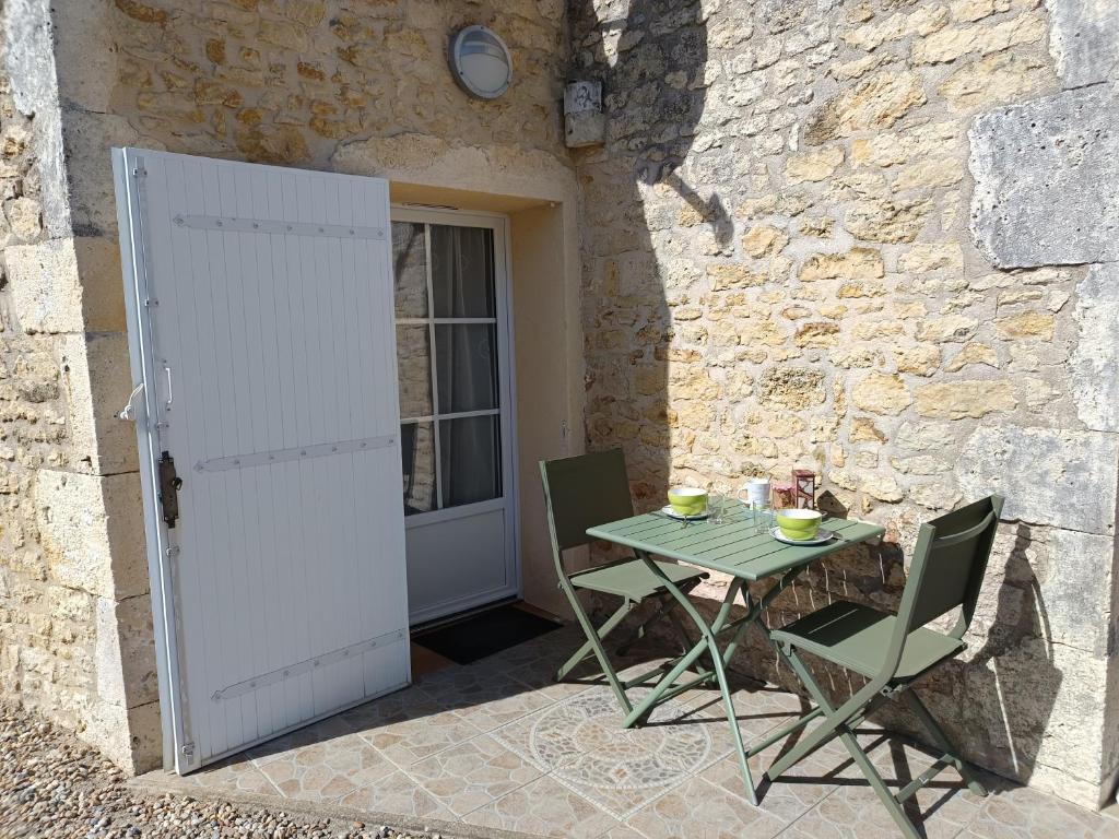 a table and chairs in front of a building with a door at La Flottille, La Cotinière in La Cotinière