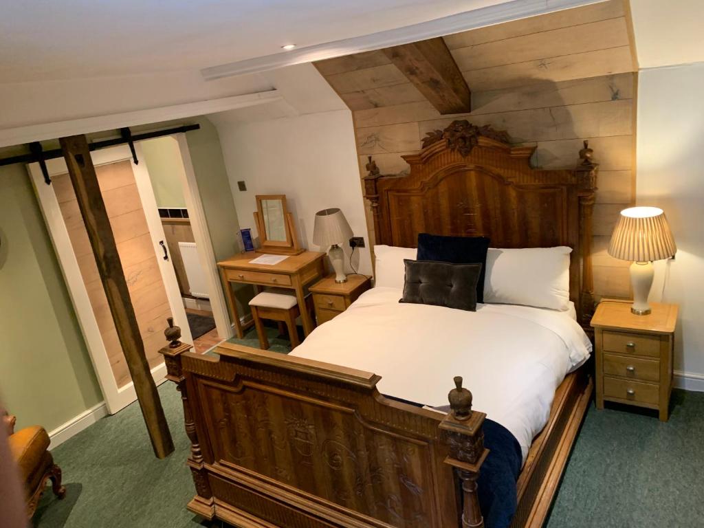 a bedroom with a large bed and a desk at The Kings Arms Pub in Stratton on the Fosse