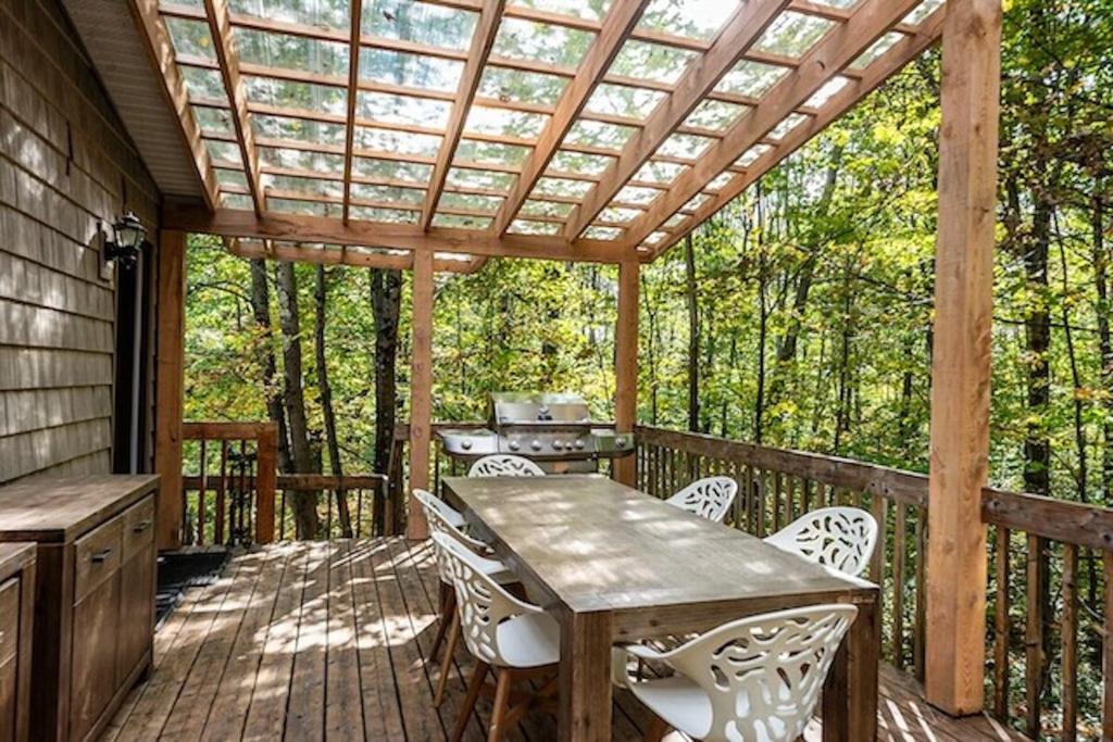 a wooden deck with a table and chairs at Ideal getaway - Ideal retreat in Lac-Brome