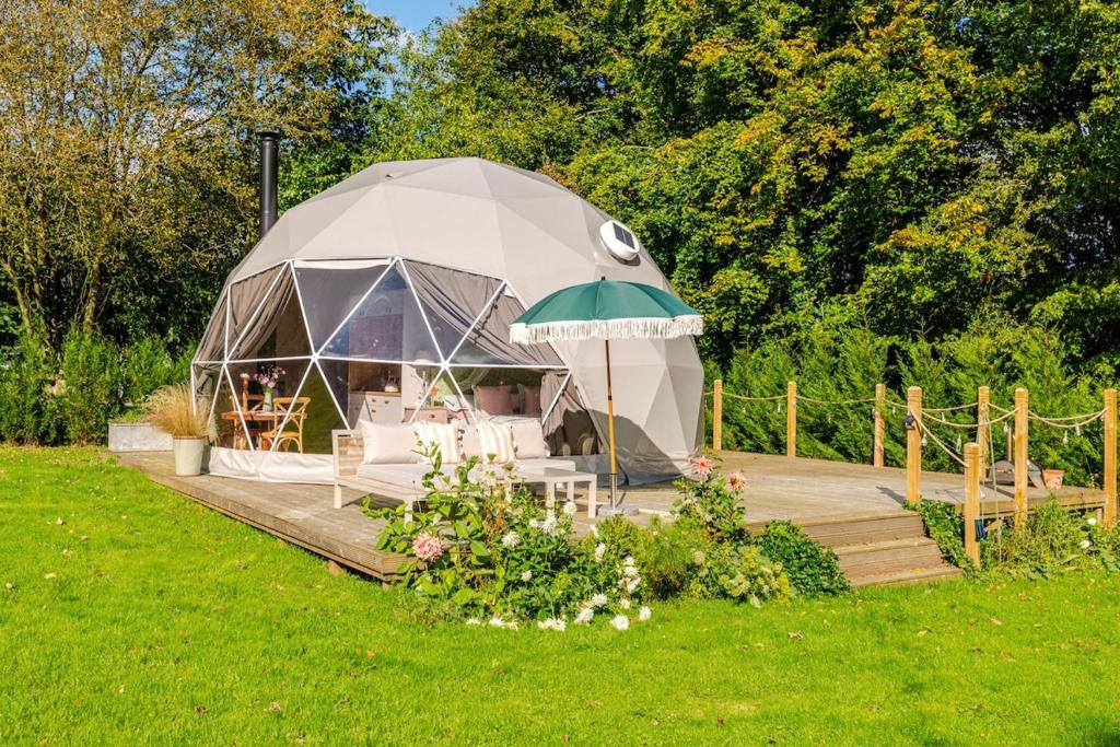a yurt with chairs and an umbrella on a wooden deck at 53 North in Bodham