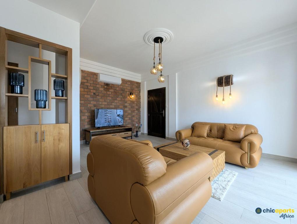 a living room with a couch and a tv at Chic apart with a view in Yaoundé