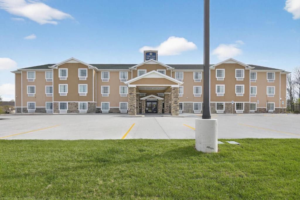 a large brick building with a pole in front of it at Cobblestone Hotel & Suites - Eaton in Eaton