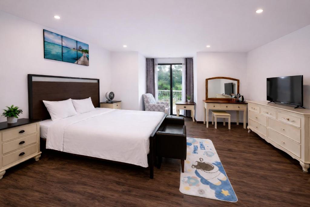 a hotel room with a bed and a television at Camly Chic Villa in Da Lat