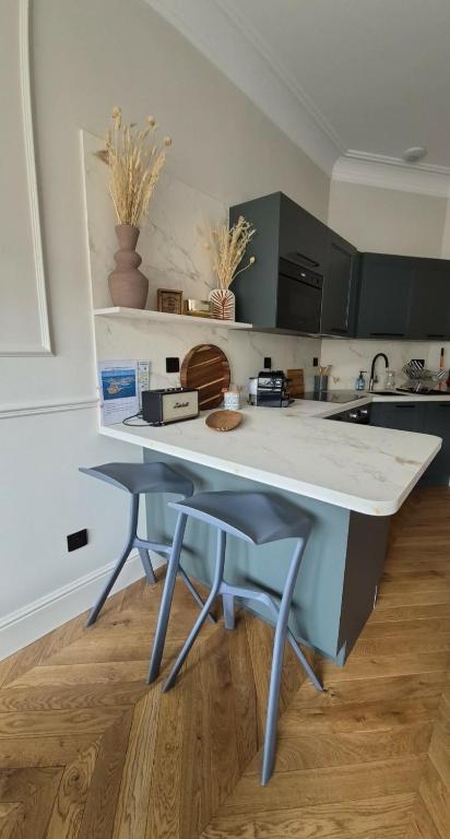 a kitchen with two stools and a counter top at Appartement duplex Granville in Granville