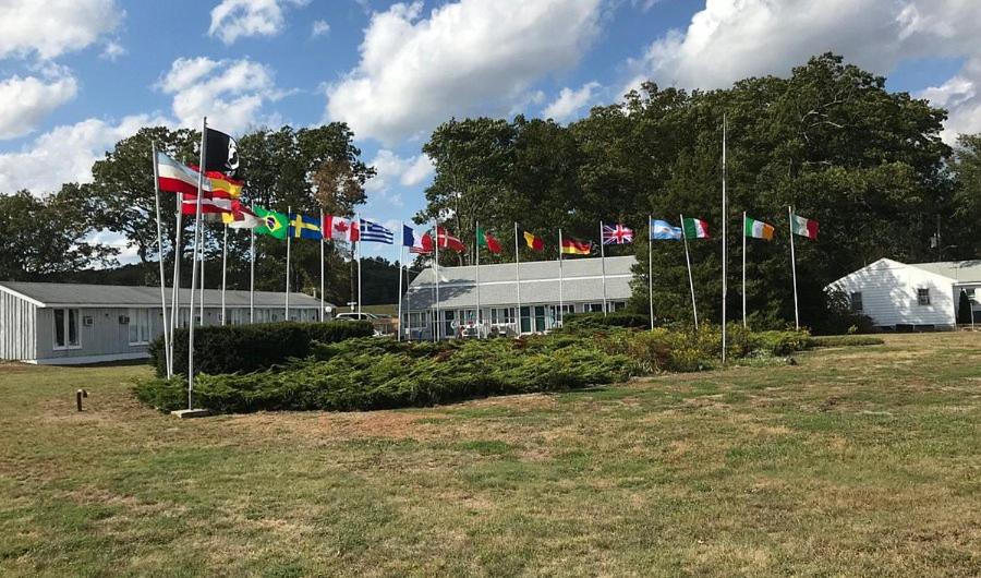 a group of different flags in front of a building at Pineapple Inn in North Attleboro