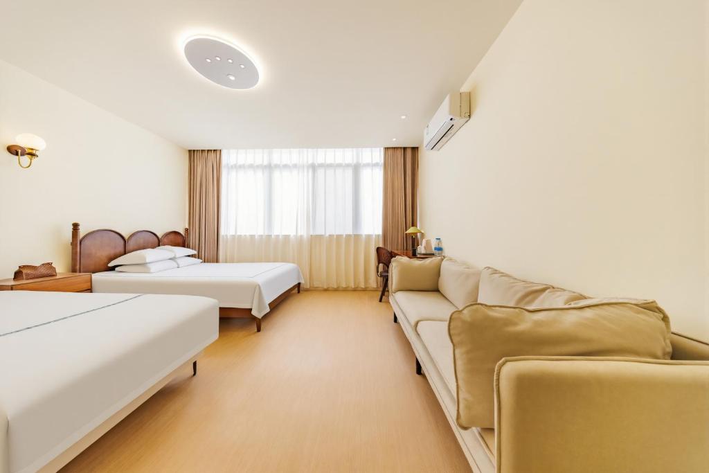 a living room with two beds and a couch at Boyi Apartment - Shanghai National Convention and Exhibition Center Branch in Shanghai