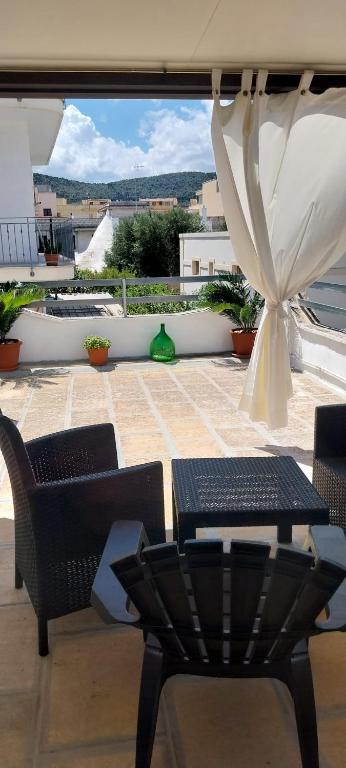 a patio with a table and chairs and an umbrella at LA CASETTA in puglia in Montalbano