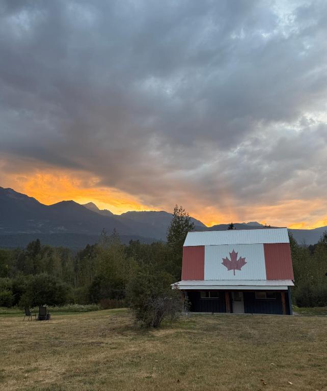 a barn with a red and white roof in a field at Hot Tub Nights & Mountain Mornings PÜR in Golden