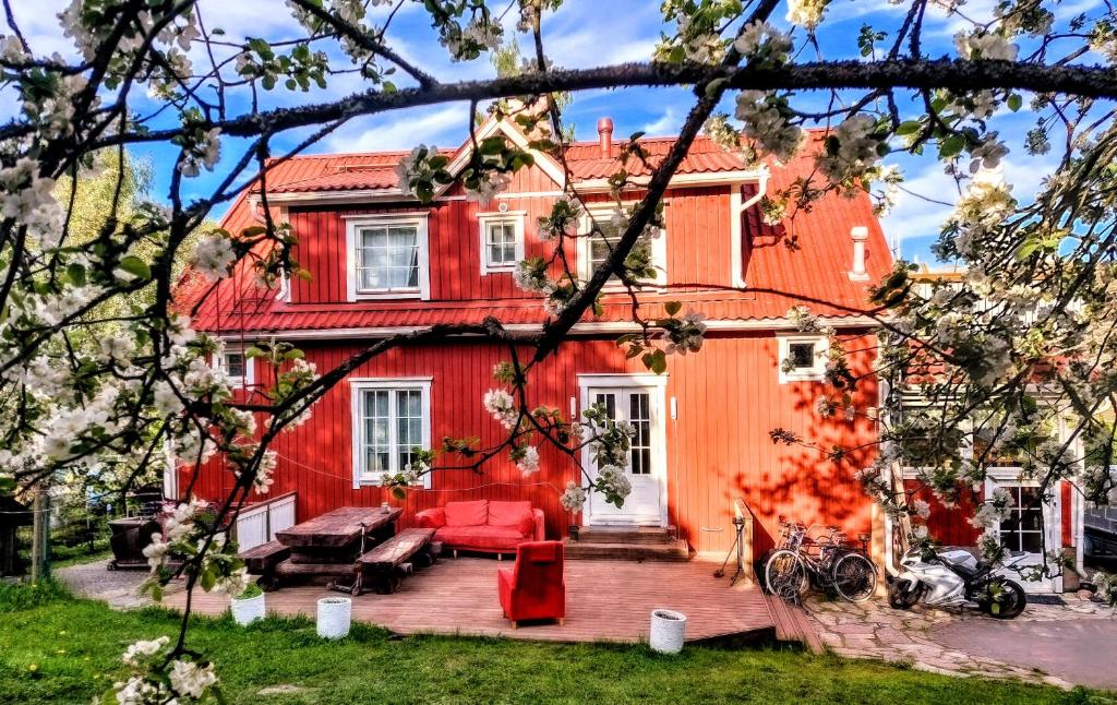 a red house with a red couch in front of it at 120 yrs. old log house in Kuopio city centre in Kuopio