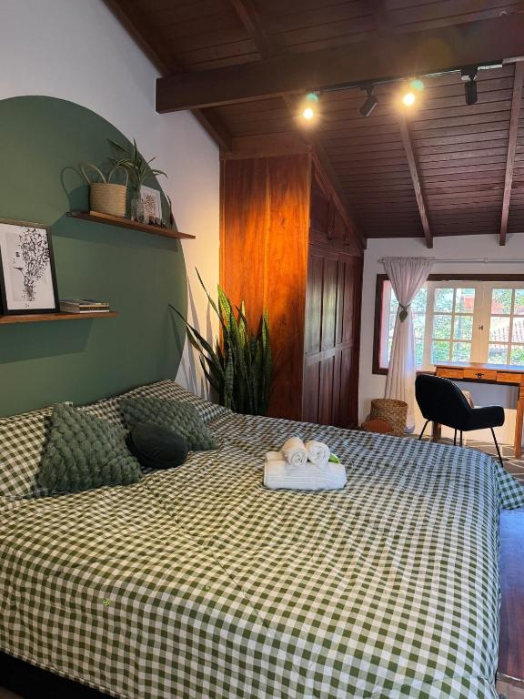 a bedroom with a bed with a checkered blanket at Chalé da Praia Paraty in Paraty