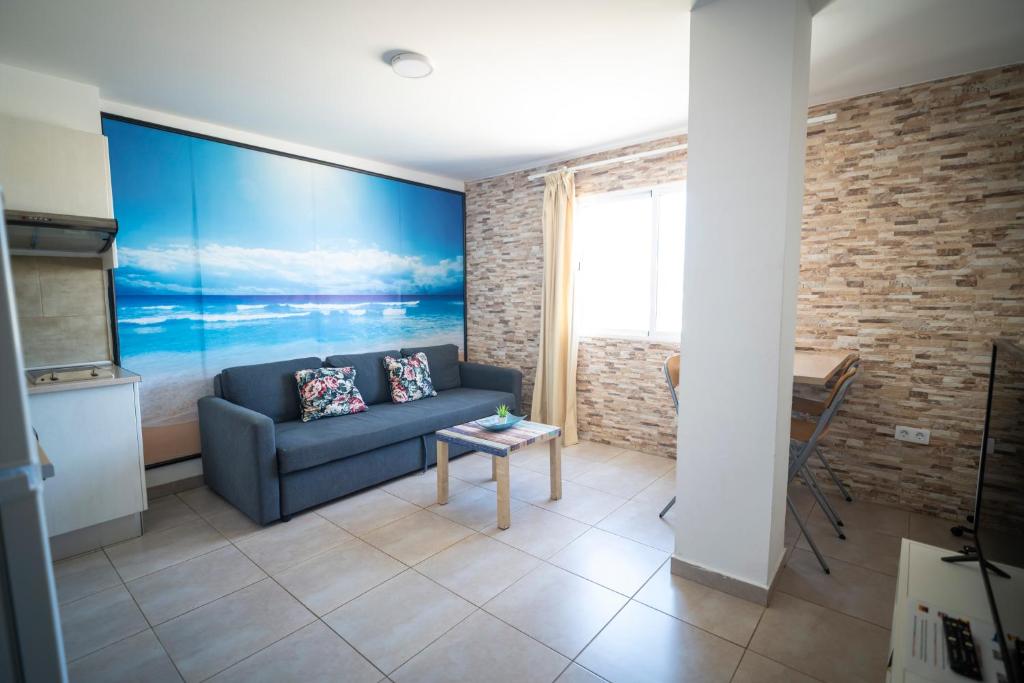 a living room with a couch and a blue wall at Edificio Prieto VIV 4 in Puerto del Rosario