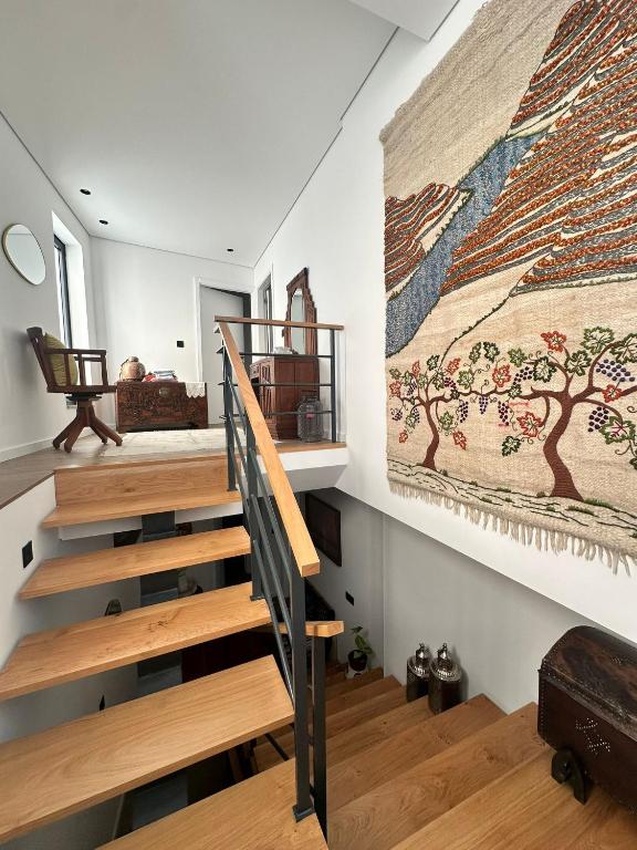 a staircase in a house with a painting on the wall at Azenha Ah Bô! in Alijó