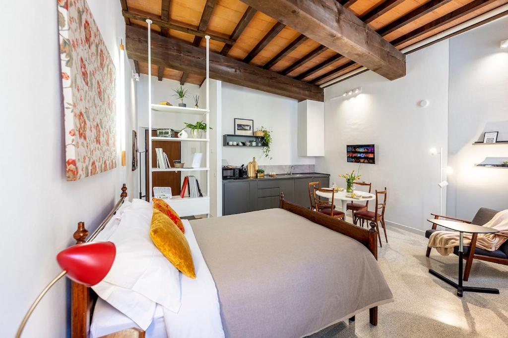 a bedroom with a large bed and a dining room at XX Settembre Studio Apartment in Parma