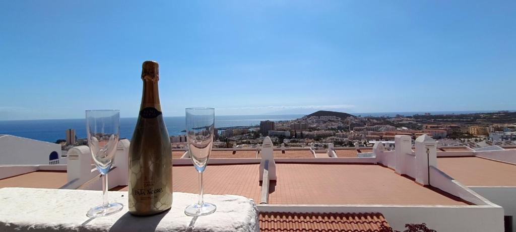 a bottle of wine sitting on a table with wine glasses at Apartmán Vlasta in Arona