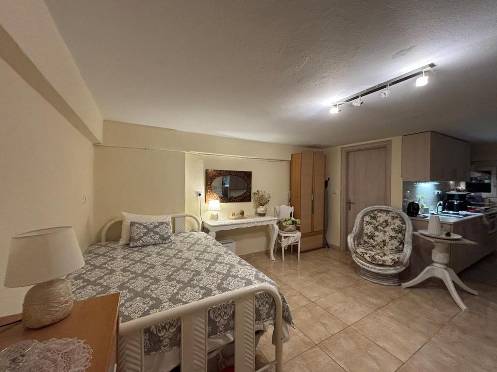 a bedroom with a bed and a table and chair at Sofies Studio in Nea Peramos
